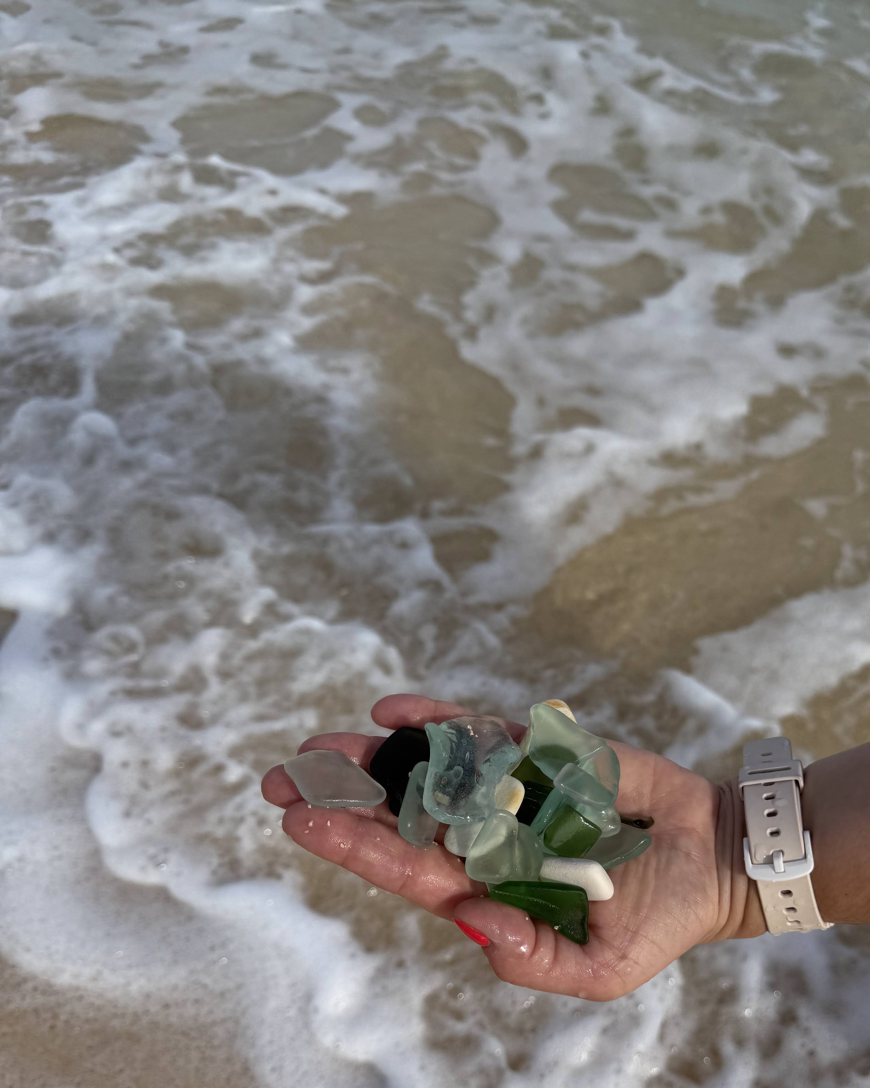 Hands holding sea glass at the workbench